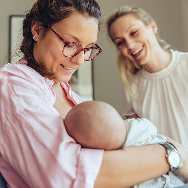 Women smiling at newborn baby